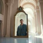 Persona mirando su reflejo con serenidad, simbolizando la superación del síndrome del impostor y el fortalecimiento de la autoestima.